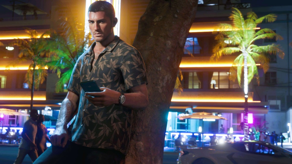 Jason leans against a tree in GTA 6, surrounded by neon lights and nightlife vibes in Vice City.