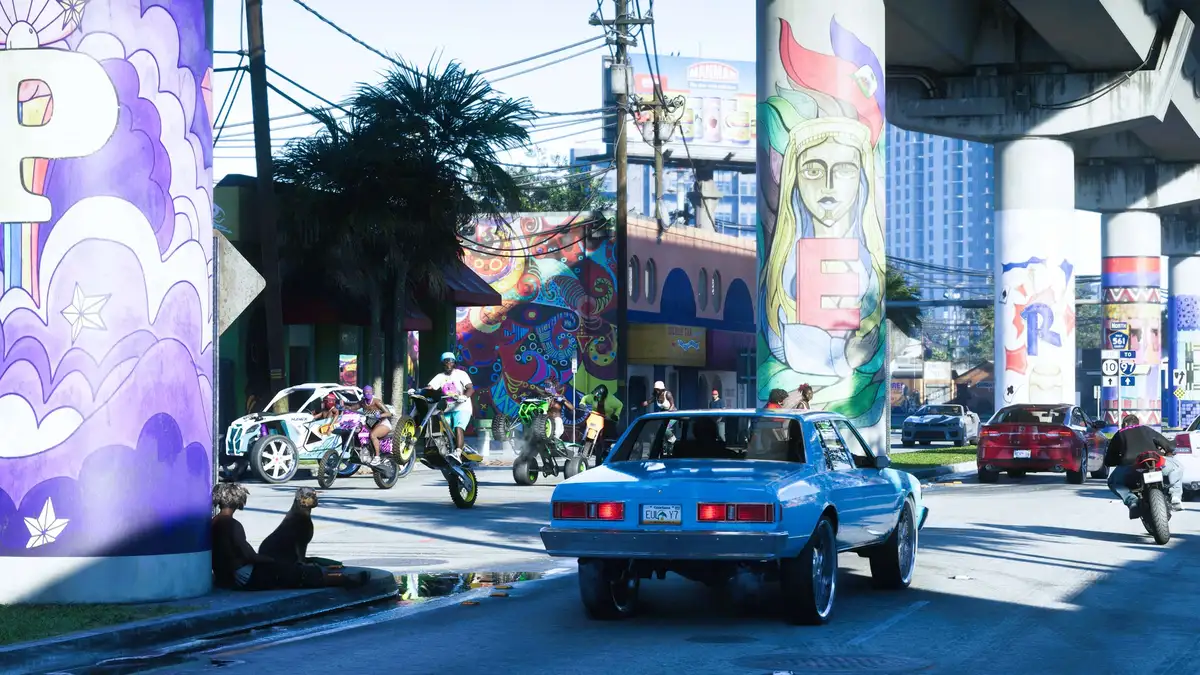 A crowded GTA 6 street scene featuring NPCs on bikes, cars, and pedestrians under colorful murals in Vice City.