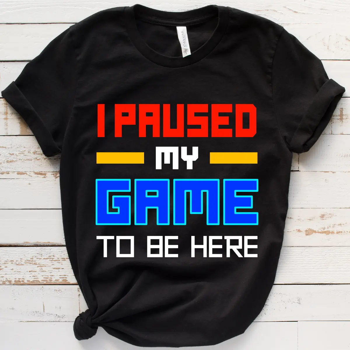 Black t-shirt with bold text reading "I Paused My Game to Be Here," a colorful and funny gaming shirt for gamers with attitude.